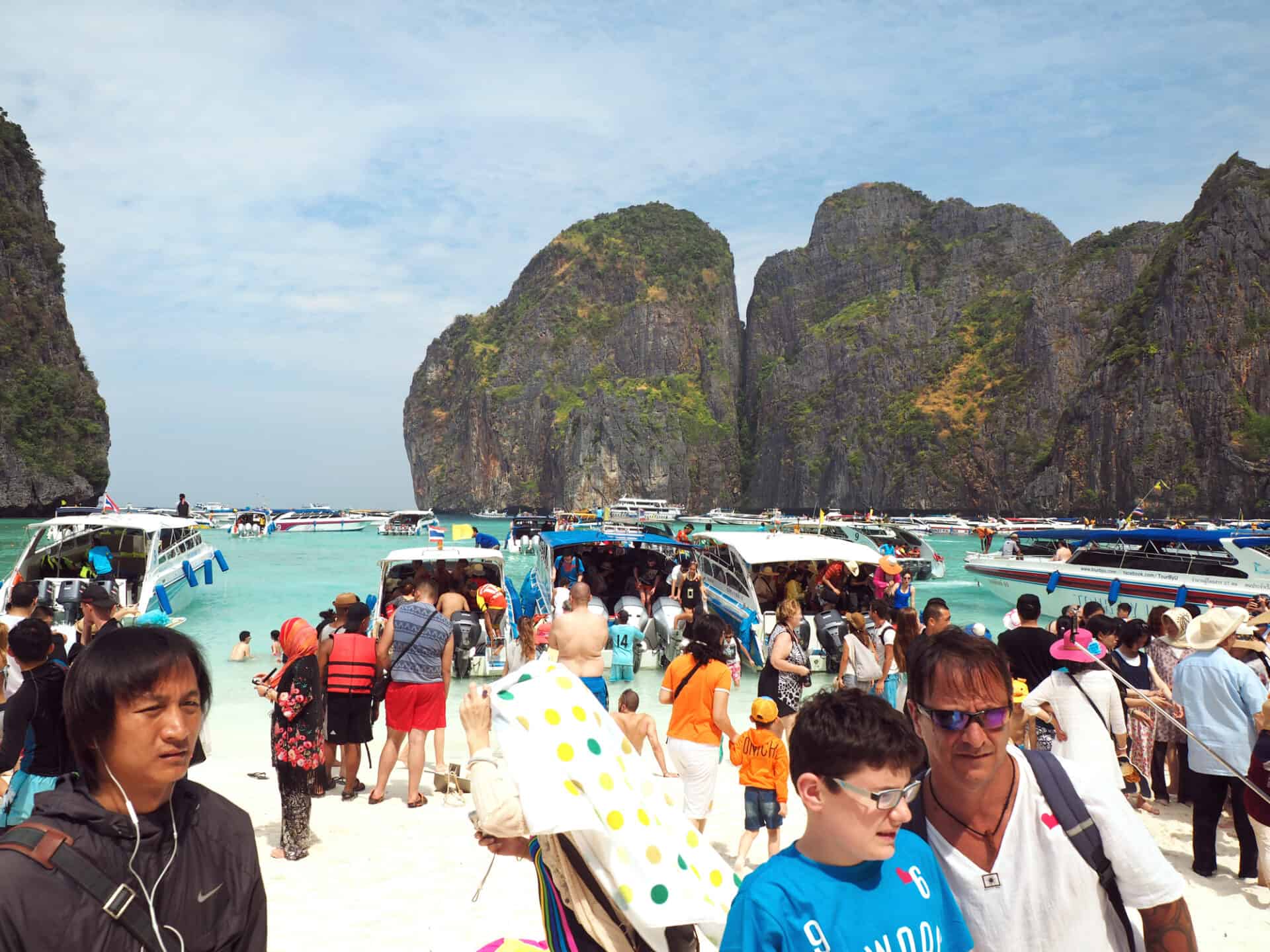 Crowds of visitors enjoy a day trip at Maya Bay, one of the iconic beaches of  Phi Phi  islands of Southern Thailand, featured in the movie "The Beach" starring Leonardo DiCaprio. 